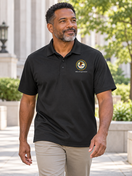 Black men's Dri Fit polo with source DOJ seal and exact Office of Legal Counsel caption outdoors at a civic office