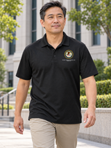 Black ATF men's Dri Fit polo with its exact source DOJ seal and Alcohol, Tobacco, Firearms and / Explosives caption at a federal office exterior