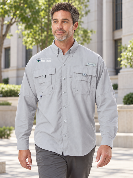 BFS men's Columbia Bahama II long-sleeve shirt in Cool Grey, with the original building, star and blue-and-green symbol with Bureau of the Fiscal Service lettering above the right chest pocket, at an administrative office campus.