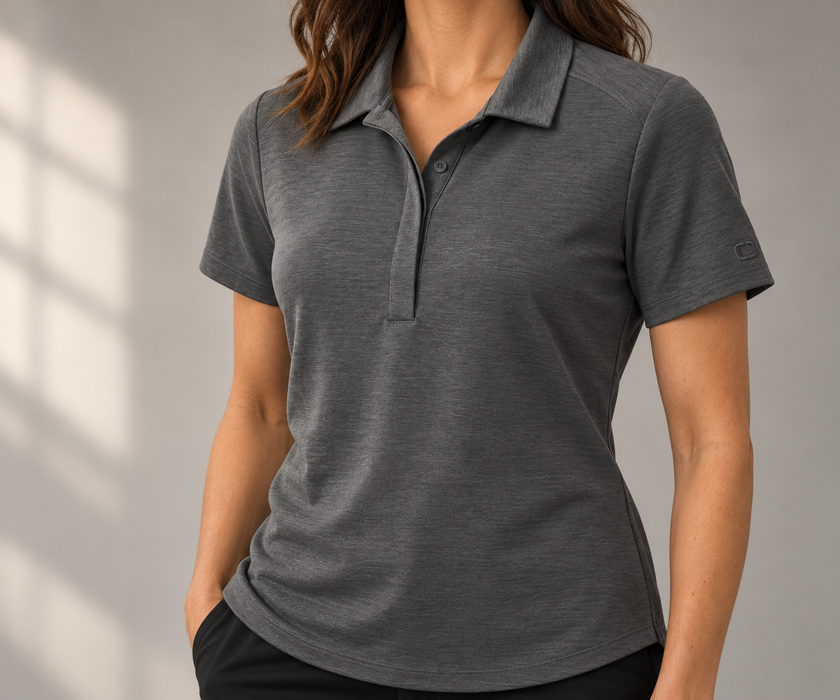 Woman wearing the gray OGIO LOG152 Motion Polo against a simple neutral background